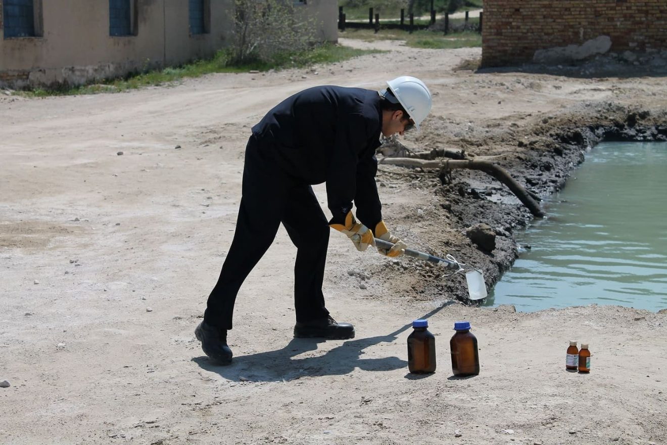 collecting a water sample at the site in 2014
